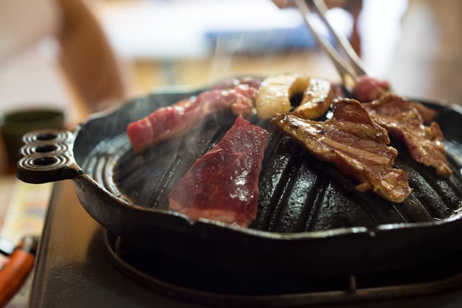 〈あんべ〉では南部鉄器のジンギスカン鍋で焼く。まず片面を肉のふちの色が変わるくらいまで焼く。裏返したら、もう片面は軽く炙るくらいで充分。
