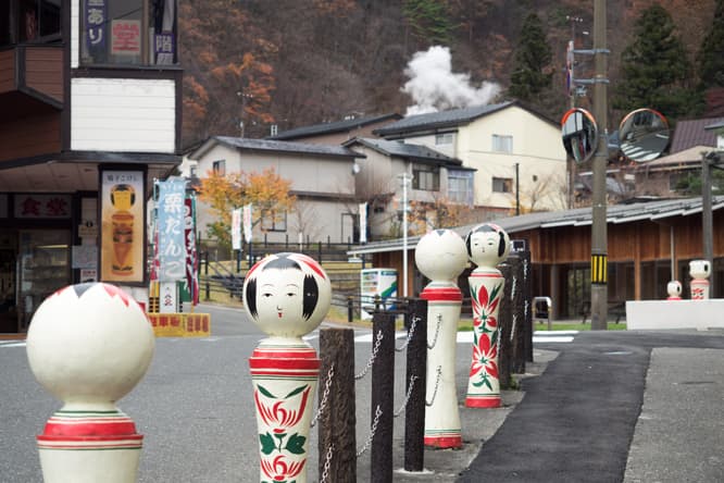 坂道の多い街並みに大型観光ホテルや老舗旅館、公共浴場などが立ち並び、白く立ち上る温泉の噴煙にも旅情をそそられる。駅や温泉街の看板にはこけしが描かれ、こけし型のガードレールまで見られるなど、町中がこけし一色。ユル渋い温泉地だが、地図を手に散策する観光客には、若い世代も多い。