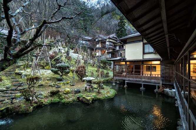 斜面を削るのではなく、生かしたまま増築を繰り返した建物。春は桜、夏はホタル、秋は紅葉、冬は雪景色と季節ごとの庭の景色も〈向瀧〉を訪れる楽しみ。