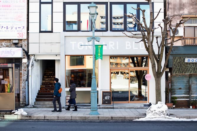 〈とんがりビル〉外観。ショーウィンドーからは、山形の各地に産地があるこけしが通りを眺める。