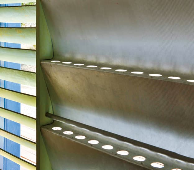 湿気を避け、通気性を考慮したサンシャッター（波形遮蔽板）。左隣は、採光を調節できる木製ブラインド。