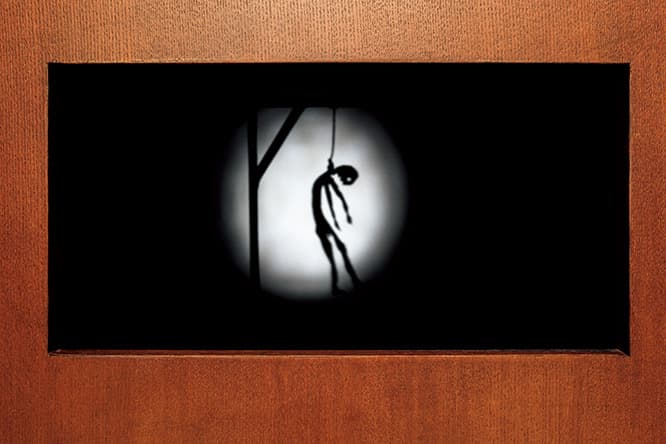 部屋の壁に骸骨や首を吊る人など不穏なイメージの影絵が現れる。その影絵のもとになっているのは段ボールや扇風機などの日常的な素材だ。死と日常とが連続していることを思わせ、同時にユーモアも漂う。
