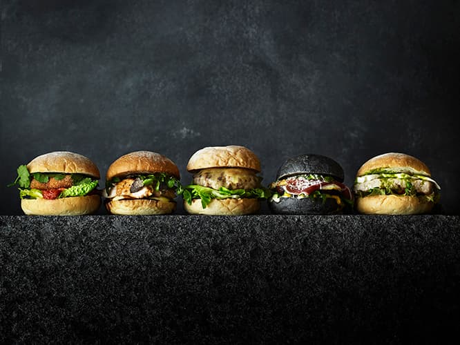 左から、シンガポールチリクラブバーガー3,800円、ロッシーニ風チキンバーガー3,900円、和牛チーズバーガー3,700円、アスパラガスのブラックバーガー3,800円、メカジキのグリルバーガー3,600円(すべて税込・サ料別)。