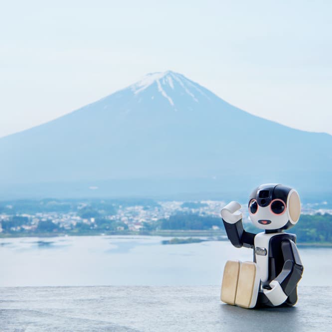 ショートトリップで訪れたホテルのテラスから、湖越しに富士山を望む。旅の思い出を共有しようと、《ロボホン》で目の前に広がる絶景を撮影することに。《ロボホン》との会話も弾みます。