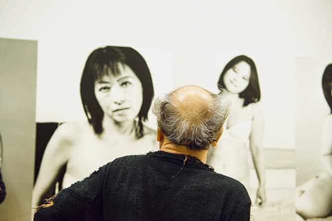 1998年から続く人気連載シリーズ『人妻エロス』。補正・調整し、画一化された美しさを作り上げようとする現代のグラビア写真に対し、荒木はさまざまな年齢の肉体をむき出しにする女性を銀塩写真に収め続けている。
