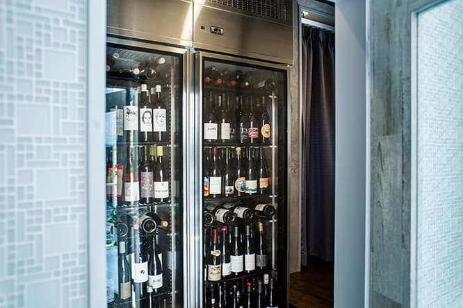 扉を開けるや、ワインセラー。ここは、飲む！　レストラン。この店が誕生するきっかけを生んだ北海道のワイナリー〈農楽蔵〉のボトルももちろん貯蔵。