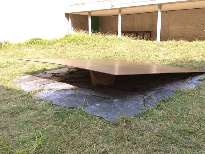 屋外の芝生に石盤石を方形に敷き詰め、石と鉄鋼板を置く。Relatum Dwelling (A), 2017 (c) Lee Ufan et frère Marc Chauveau