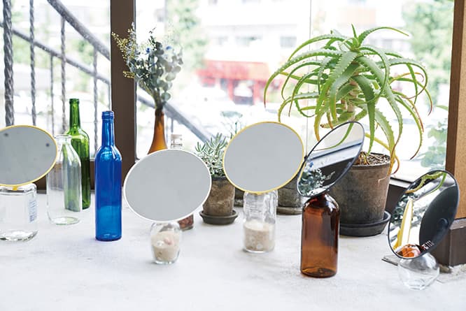 《サンフラワー》各3,000円。3色展開。φ186×H21mm。厚さ1.3mmの国産鏡に飛散防止フィルムを使用。グリップ部分は柔らかい樹脂性で、瓶の口に差し込むことで固定される。