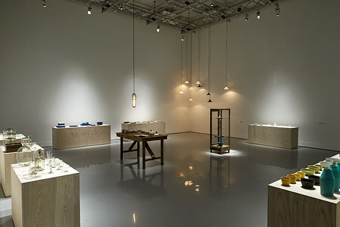 「そばにいる工芸」展のメインの展示室。作家ごとの作品を並べたほぼ同じ高さの展示台を壁際に配置し、作品同士が対峙するような構成にした。