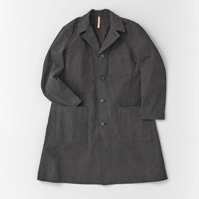〈ARTS&amp;SCIENCE〉のデザインに〈MAN-TLE〉のファブリックを落とし込んだワークコート。腰から裾に掛けてゆるやかに広がりをみせるワークコートは、大き目のポケットと深めのスリットが入り機能性と動きやすさを兼ね備えた作りに。87,000円。