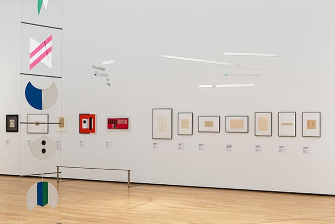天井から下がっているのが「役に立たない機械」のシリーズ。壁には初期のスケッチや絵画が並ぶ。