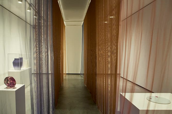 天井から吊るしたテキスタイルで空間を分割。その重なりとモアレが、展示作品の見え方を変化させる。