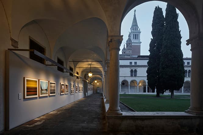 Venetian Way : 元修道院の回廊の壁を使い、ヴェネチアとその周辺地区にある陶芸、ガラス、レースなど21の工房の様子を収めた写真をぐるりと展示。(c) Alessandra Chemollo