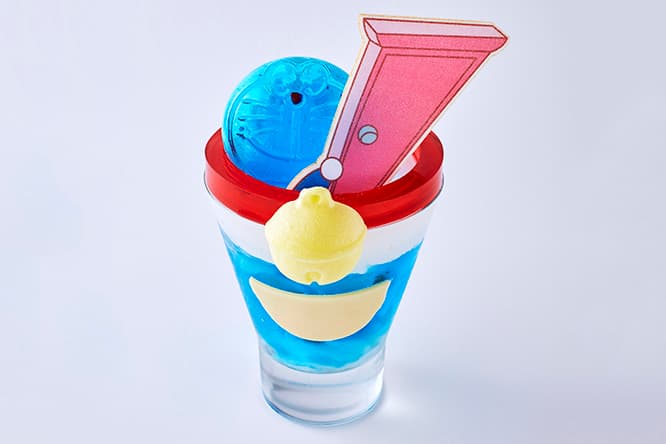 ドラえもんの四次元ポケットからどこでもドアが飛び出す《どこでもドアパフェ》1,380円はフルーツやパンナコッタなどを詰め込んだパフェ。