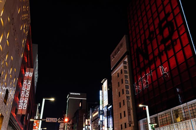 夜の銀座。向かい合わせの〈シャネル銀座ビル〉と〈松屋銀座〉が呼応するように空間を赤く彩っている。©CHANEL 