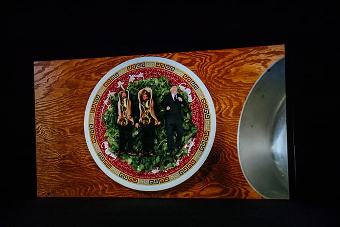 「Cosmic Generator」（2017）。ショートフィルムと、立体作品のインスタレーションという二部構成。インスタレーションではアジア系経営の小間物屋を再現した。『Cosmic Generator』のショートフィルムから。フード屋台のシーンから一転、中で人がモゾモゾとユーモラスに動くタコスの映像に。バース美術館で2018年4月30日まで。