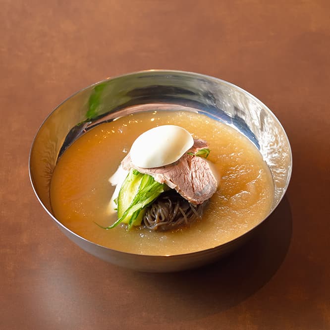 葛冷麺1,200円。牛スネ肉、ゆで卵、キュウリの千切りがのってくる。途中で酢を加えて好みの味に調整をする。