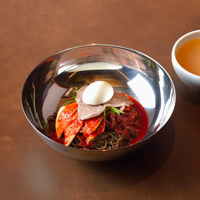 葛ビビン麺1,200円。特製旨辛タレと麺をよく和えてから食べる。麺と別添えのスープをそれぞれ味わってから、麺の器にスープを注いで食べ進める。
