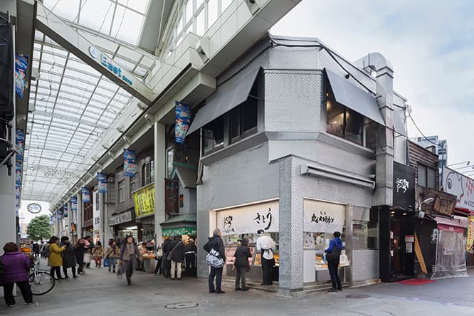 手仕事の跡が残る近隣商店のファサードとリンクするよう、アルミ板はすべて職人が手作業で貼り付けた。油汚れなどを落としやすいという機能性も、アルミを採用した理由の一つだという。