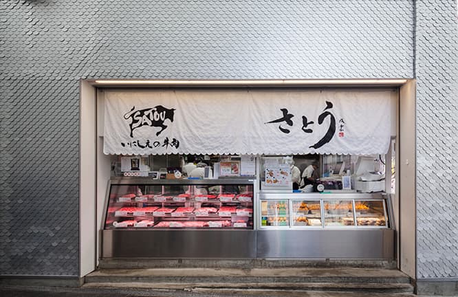 書道家・武田双雲の書が存在感を放つ暖簾。ショーケースのプライスカード横にも、円形のロゴがあしらわれている。