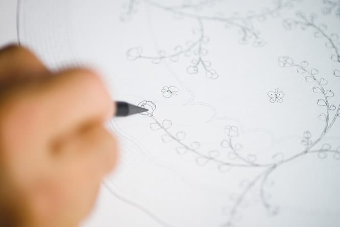 皆川が紙に描いたこの線を、マエストロが皿に描き、デザイナーが配置を考えた。