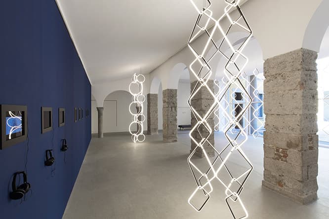 ミラノ市内の〈フロス〉ショールームに光の彫刻が出現！　幾何学形のLEDユニットで構成される新作のモジュラーシャンデリア《アレンジメンツ》を使った、マイケル・アナスタシアデスのインスタレーション。