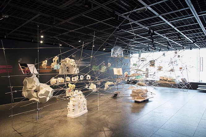 3階の展示風景。大小さまざまな模型やスケッチがディスプレイの棒とともに浮いている。「作品だけで閉じてしまうのではなく、作品同士の関係性を見せたかった」（平田）。