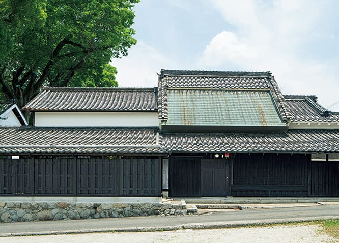 正面外観。傾斜の異なる屋根の組み合わせが大和棟の特徴。右半分は改修で、左半分は新設。新設部分に古瓦、漆喰の壁、木の塀を用い、既存の建物となじませた。