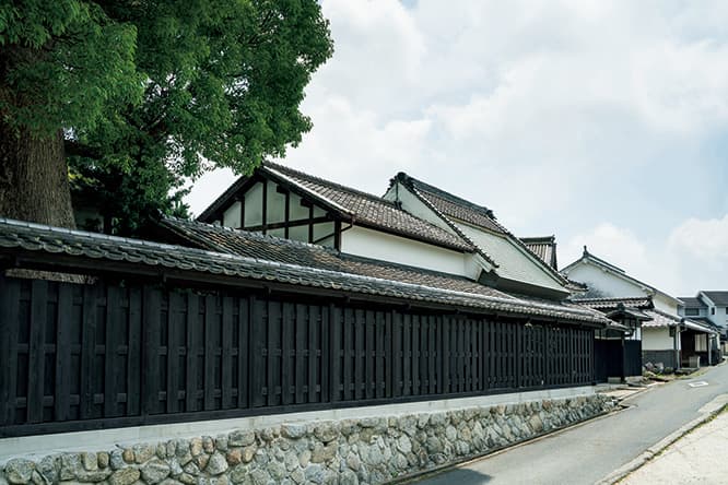 旧街道の景観になじむ焼杉の塀。今年5月、メンテナンスのため保護塗料を再塗装し、美しさを保っている。
