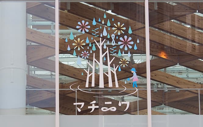 〈マチニワ〉ロゴ。《水の樹》の花芽が美しい花となり、結実し、やがて新たな芽吹きにつながる……その輪廻を水滴のメビウスリングで表現した。 