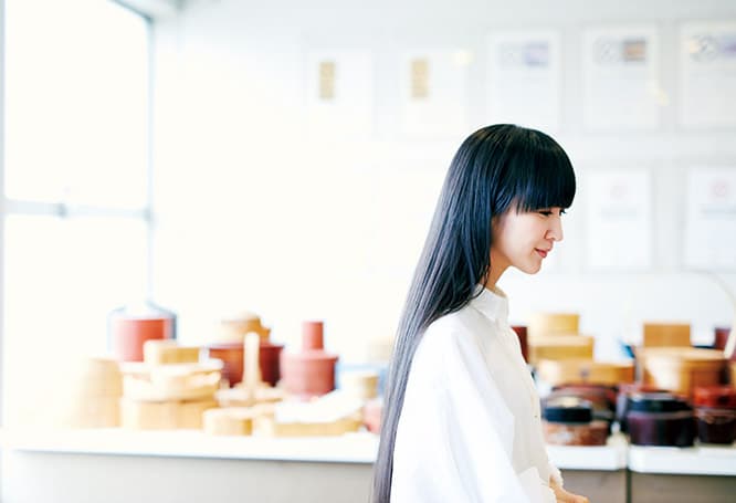曲げわっぱは、薄く挽いた天然杉の板を曲げてつくる伝統工芸だ。"大館曲げわっぱ"の〈柴田慶信商店〉に足を踏み入れたとたん、「わあ、木のいい香り」とうれしそうに目を輝かせたかしゆか店主。弁当箱をセレクト中。