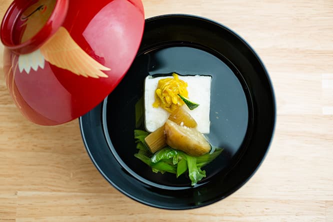 「帆立しんじょうと秋なすのお椀」。菊花、九条ネギ、白菜添え。ふたをとった瞬間、フワッと鼻腔にくる香りもごちそう。鰹節と昆布でとった一番出汁は、マイルドでふくよかな旨みに特徴がある。