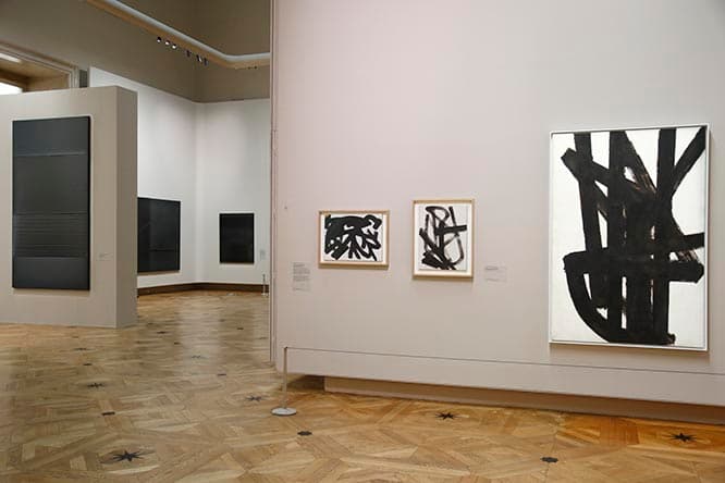 ルーブル美術館サロン・カレでの展示風景。時系列の展示で、入口に近い右手前の壁にかかる小作品は1946年から47年にクルミの果皮から作った褐色の塗料で描かれた初期の作品群。
(c) Musée du Louvre / Antoine Mongodin (c)  ADAGP, Paris 2019 