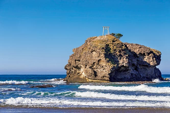 白兎海岸は日本最古の恋愛物語の地として知られる。写真の淤岐島（おきのしま）は白兎海岸の沖合約150mに位置する島。この島と陸を結ぶ岩礁は神話の中のワニの背中とされ、兎はそれらを渡ってきたと伝えられる。　鳥取県鳥取市白兎603 TEL 0857 59 0047（白兎神社）。