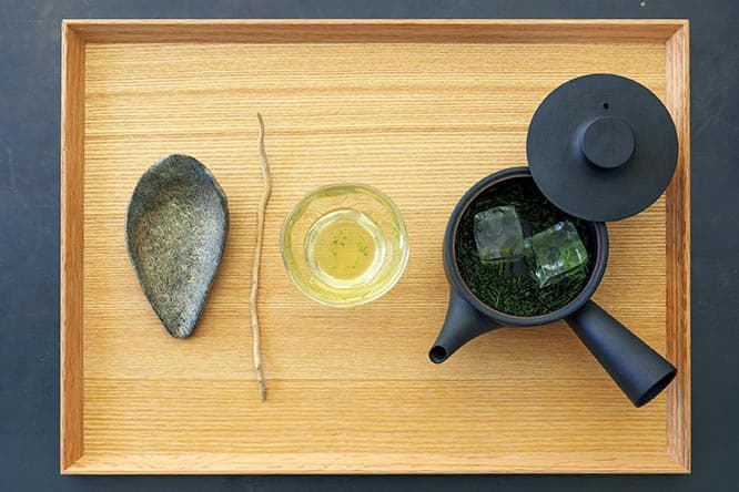 「天竜 氷蒸し四煎」750円。はじめの二煎は氷と水で淹れ、次の二煎はお湯で淹れる。味わいの移り変わりを4度、楽しめる。茶葉は〈伊藤園〉が厳選したもの。静岡県浜松市の天竜区で摘まれた「天竜」は、朝霧が生み出す上品な甘みが特徴。珍しい「氷出し」で味わうと、お湯を注いだ時よりも深い旨みが感じられる。モダンな急須はイイホシユミコの定番アイテム。蓋の下には、菊地亨がこの店のために作ったオリジナルの蓋置きが潜む。茶則も菊地亨のオリジナル。