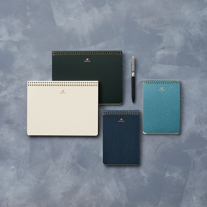 （左から）《Notebook A5》アイボリー、バンクグリーン：A5サイズ（210×148mm）、110ページ、2,860円。《Notebook A6》ダークブルー、ライトブルー：A6サイズ（105×148mm）、110ページ、2,090円。ポスタルコ  TEL  03 6262 6338。 