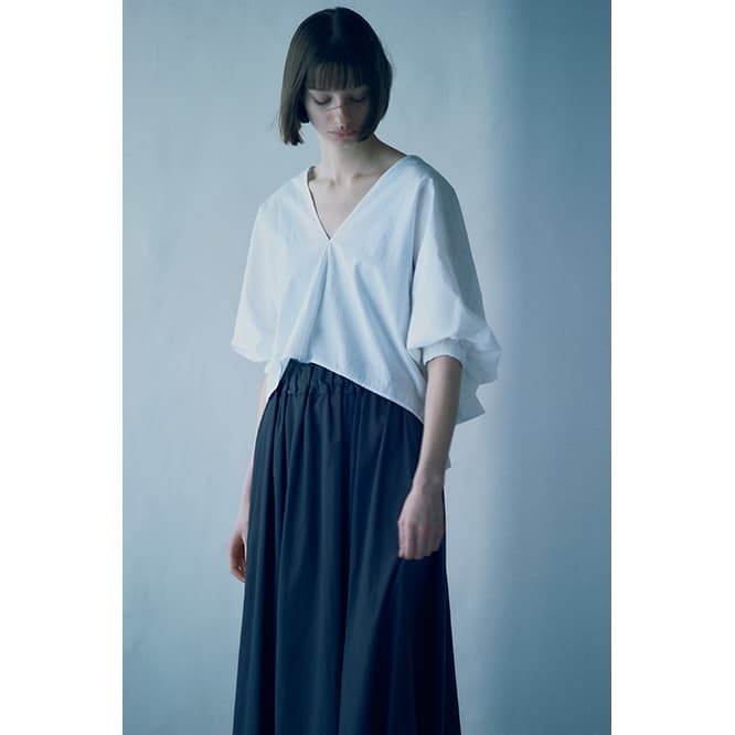 《ボリュームレススリムブラウス》17,600円、《エラススティック フレアスカート》28,800円。