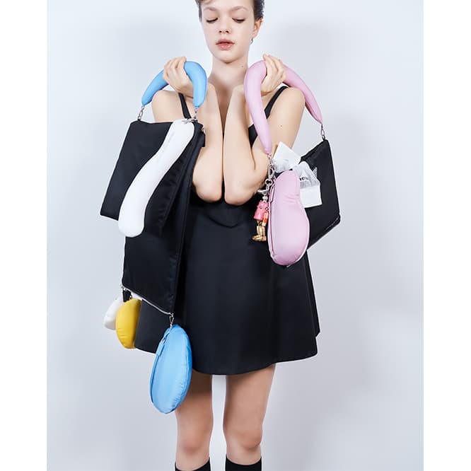 ドレス140,000円、バッグ《daln》263,000円、バッグに入ったソックス18,000円、チャーム51,000円※すべて予定価格（プラダ／プラダ クライアントサービス TEL 0120 45 1913）。
