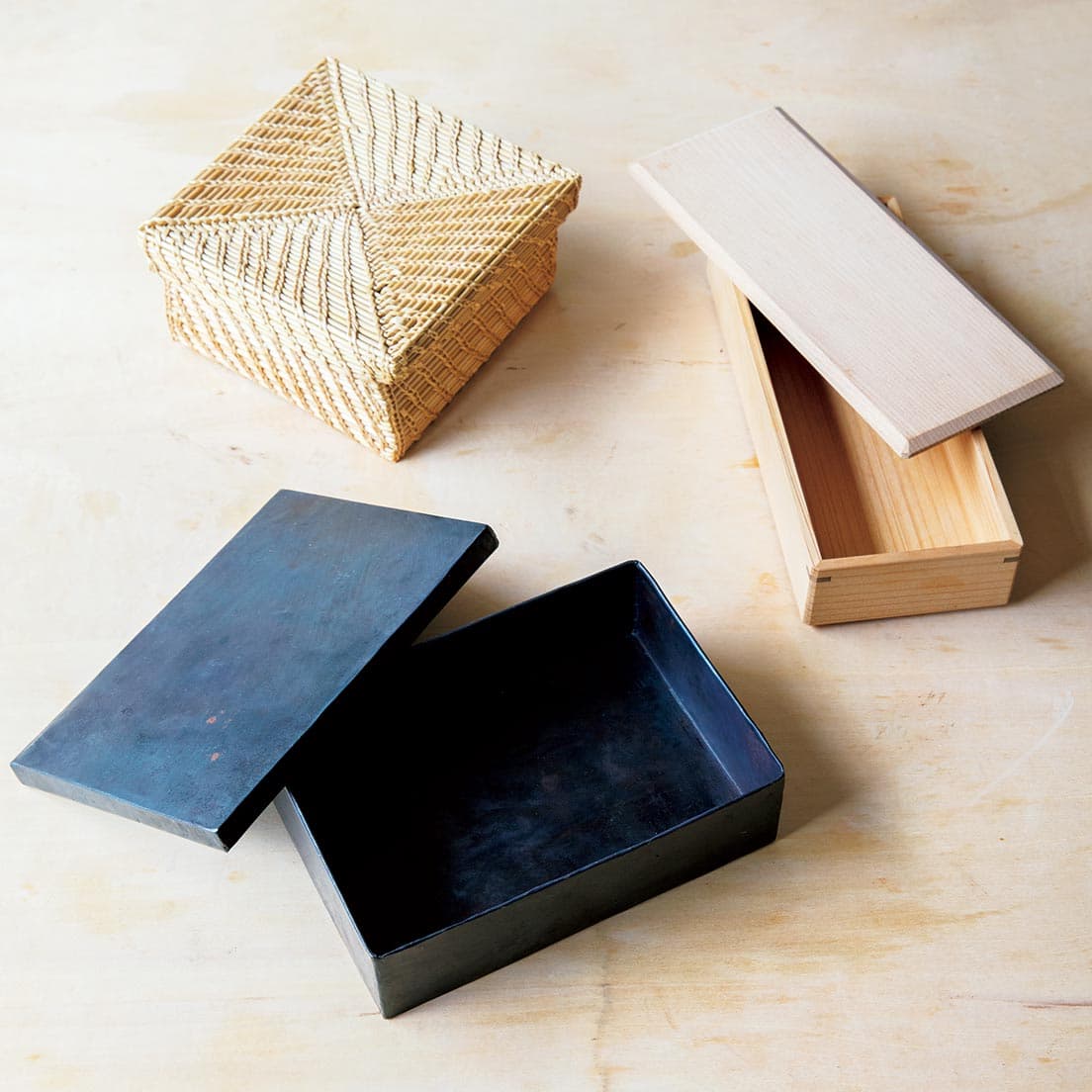 右／〈輪島キリモト〉の弁当箱。輪島の漆器に多く使われてきた石川能登の木材であるアスナロを素材に使用したもの。中でも長方形タイプは「おかずを縦に順番に入れていくだけできれいに見える」という優れもの。L21×W8.5×H4.5cm。左下／本来弁当箱ではないものを使うのもチオベン流。雑貨店で見つけた鉄製の箱。L16×W11.5×H4.4cm。左上／パンやサンドイッチのお弁当はカゴタイプを使うことが多い。写真は〈ババグーリ〉の蓋付きのカゴ。L13×W12×H6.5cm。