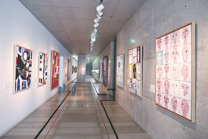 両側の壁から迫る絵。 細長い展示室には、両サイドに作品を並べた。「引いて全体を観ることは少し難しいんですけど、絵が自分に迫ってくる間を抜けていくというのは、空間の広い〈MIMOCA〉では味わえない感覚。これまでよく観ていた作品も、ちょっと違って見えるんじゃないかと思います」
