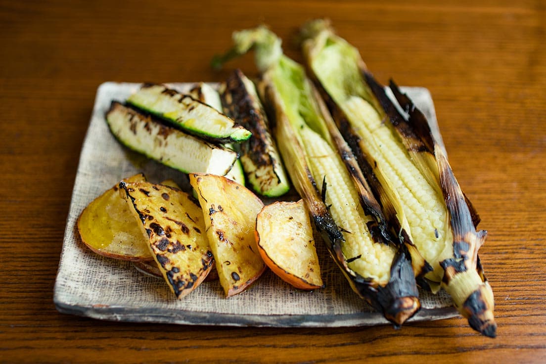 ズッキーニ、黄色いビーツなど。炭火焼きの野菜はみずみずしく、甘い！ 「サンバファーム 夏野菜盛り合わせ」1,500円。皮ごと焼いたベビーコーンは風味豊かなヒゲも食べられる。