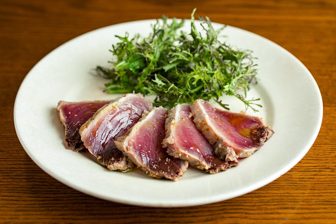 通好み「カツオの軽いぬか漬けをたたきで」1,500円。サンバファーム産の爽やかな辛味の辛子菜添え。