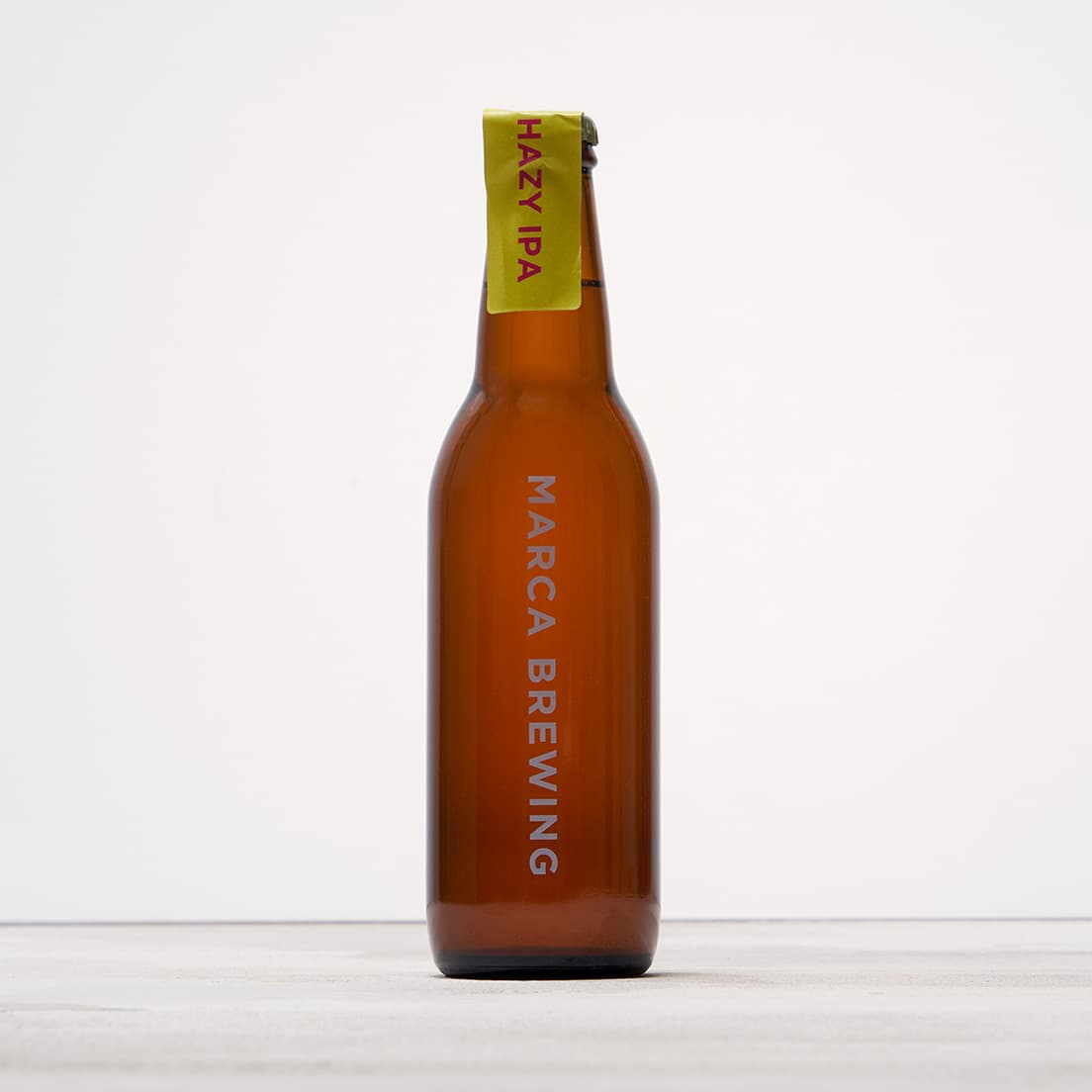 《煌：ひとくちビール》で楽しみたいのは、爽快かつフルーティーな、飲み疲れしないタイプのビール。2015年創業、大阪のマイクロブルワリー〈MARCA〉のビールは、シンプルなボトルデザインも目を引く。〈MARCA〉《HAZY IPA》（350ml）550円。問い合わせ／MARCA TEL 06 6710 9487。