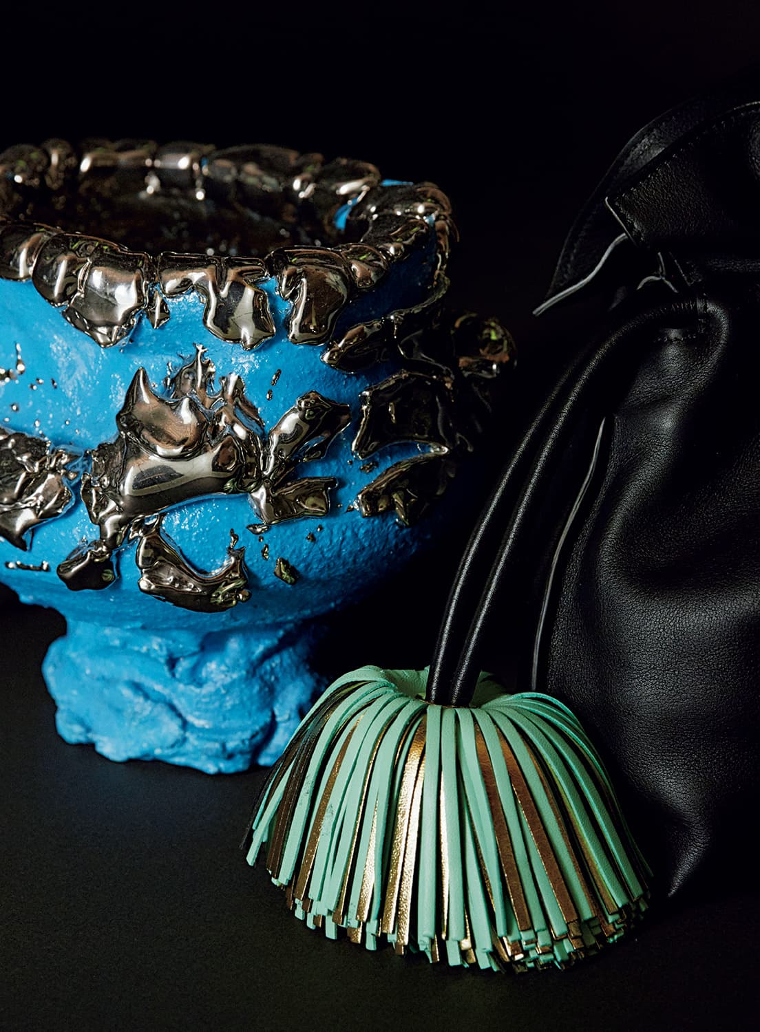 銀座にある〈カサ ロエベ 東京〉の2階に展示されている桑田卓郎の作品《Tea bowl》（2018）と桑田作品からインスパイアされたタッセル付きバッグ《フラメンコ クラッチ ベル タッセル》264,000円（ロエベ／ロエベ ジャパン カスタマーサービス TEL 03 6215 6116）。
photo_Seishi Shirakawa