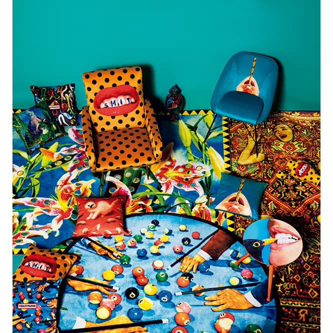 すべてSELETTI wears TOILETPAPERから、《Shit》アームチェア180,000円、《Drill》パッドチェア82,000円、《Crow》ウッドテーブルS 46,000円、ベース《Shit》《Snakes》各38,000円、クッション（右中央から時計回りに）《Drill》《Snooker》《Shit》《Kitten》《Volcano》《Snakes》各12,000円、スクエアラグ（右）《Lady on Carpet》、（左）《Flowers with Holes》各150,000円、《Snooker》ラウンドラグ110,000円（MoMA デザインストア オンラインストア TEL 0120 977 459）。