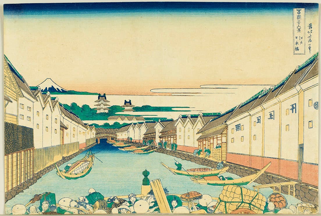 葛飾北斎《冨嶽三十六景　江戸日本橋》。人工的に造られた日本橋川の水運の様子。手前に欄干だけ見える橋には人がびっしりと行き来している。