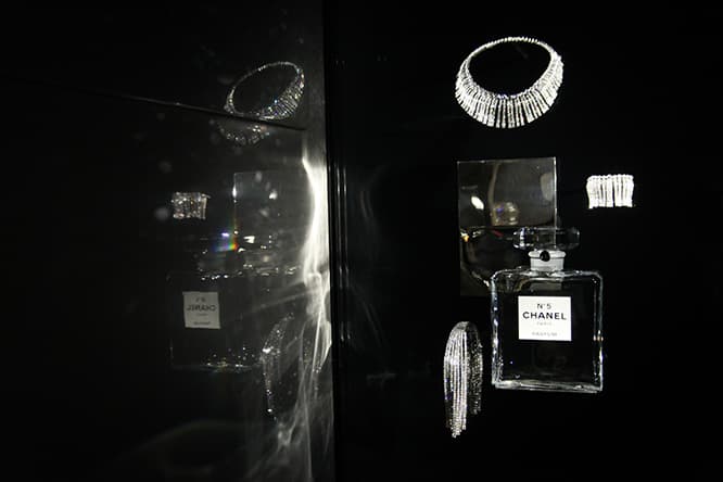 『マドモアゼル プリヴェ展』で展示されている「N°5」のボトルとハイジュエリー。「フリンジ」ネックレスとブレスレットは1932年に発表された「BIJOUX DE DIAMANTS（ダイヤモンド ジュエリー）」を復刻したもので、留め具の目立たない、しなやかで軽やかなデザインは、当時革新的なものだった。　© CHANEL All Rights Reserved