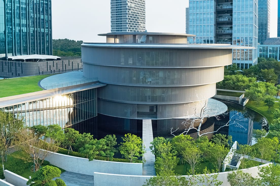 円形の建築は調和、ランドスケープは水が主題。水盤は建築を映す台座と、亜熱帯気候の暑さを和らげる親水装置の役割を果たす。振興開発区に位置する美術館は、公園から連続する緑に囲まれている。
