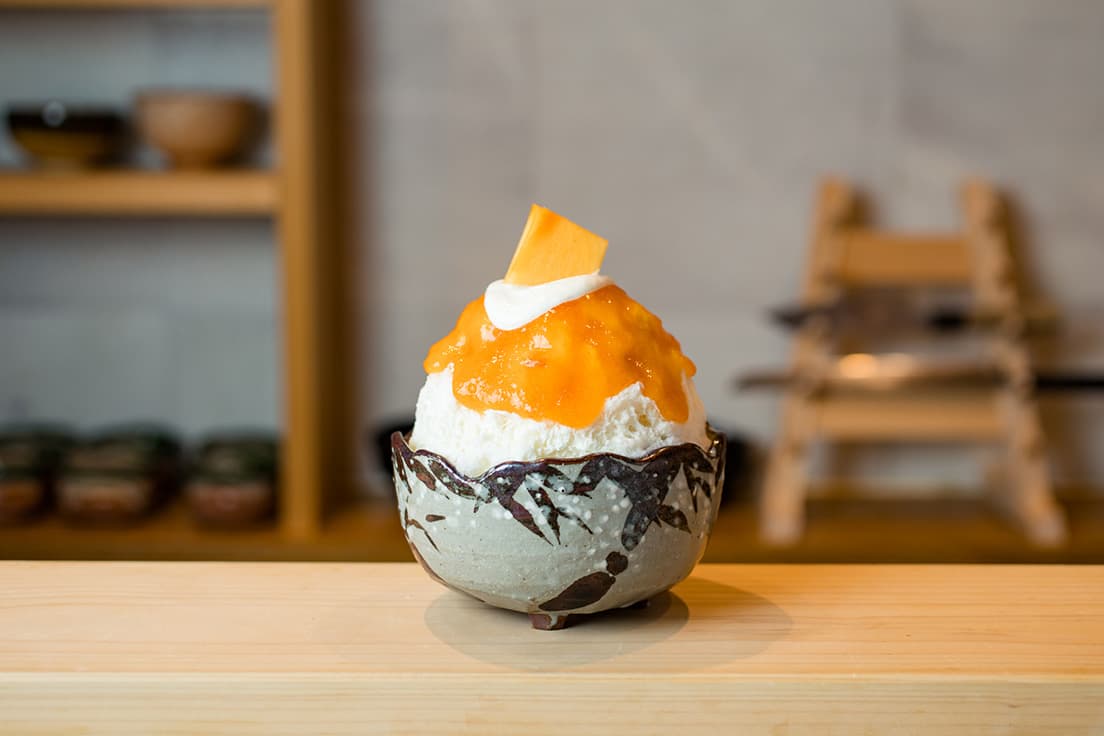 料理と甘味はすべて「甘味割烹」コース4,200円（税込）より。「かき氷 季節の旬食材」の熟成柿。佐渡のおけさ柿（品種は季節ごとに変わる）と南信州の市田柿（干し柿）を合わせたソースはとろりとした口当たり。練乳ミルク、柿の果肉を混ぜた白あん、チーズクリームが夢のような味わいを紡ぎ出す。