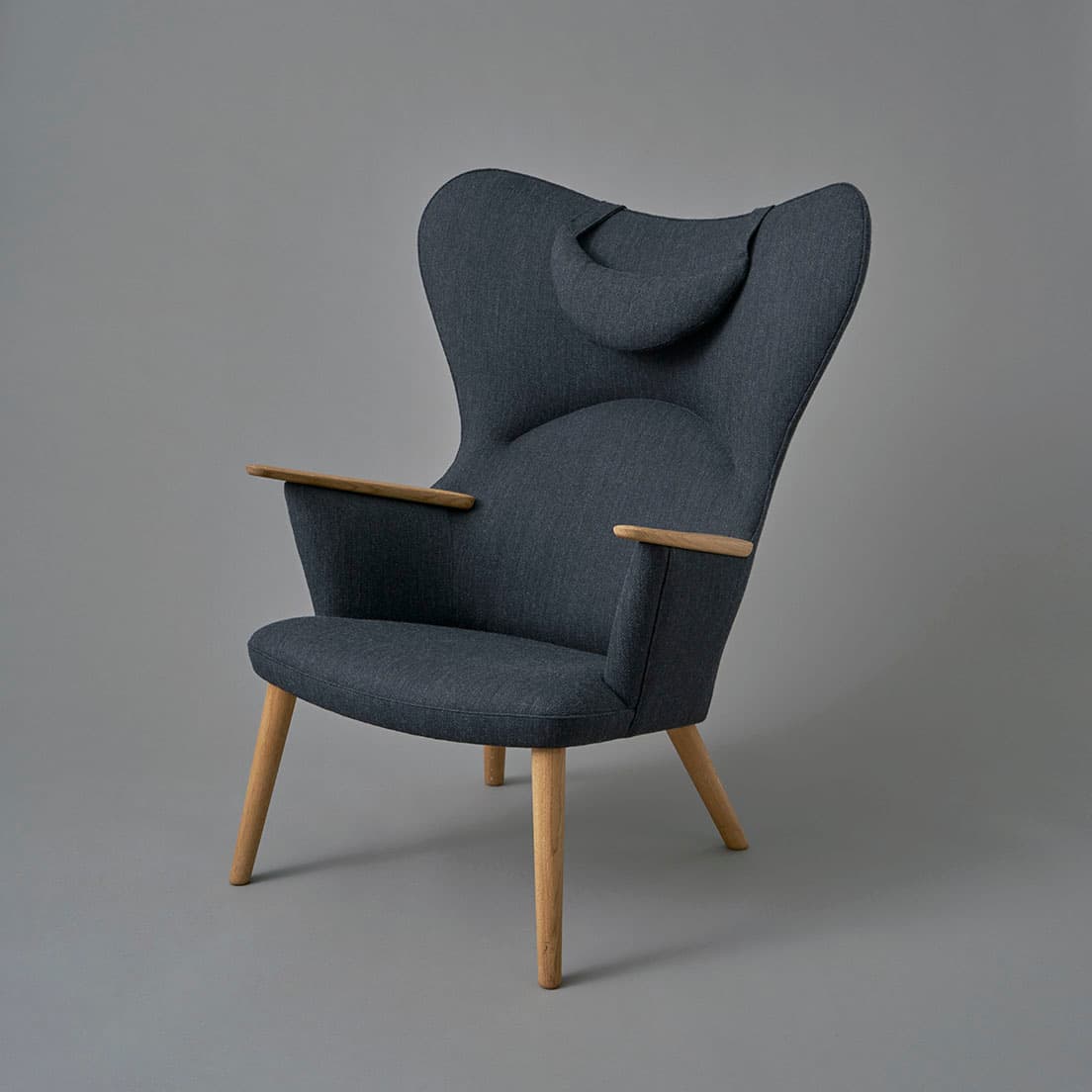 《CH78　MAMA BEAR CHAIR》（カラー：Gray Fiord191）379,500円（ネックピロー付き・本年12月末までの期間限定価格）。木素材は主にFSC®認証を受けたデンマーク産の無垢の木材を使用。張地にはクヴァドラ社のFiord （フィヨルド）を採用。　問い合わせ：カール・ハンセン＆サン フラッグシップ・ストア 東京TEL 03 5413 5421。
